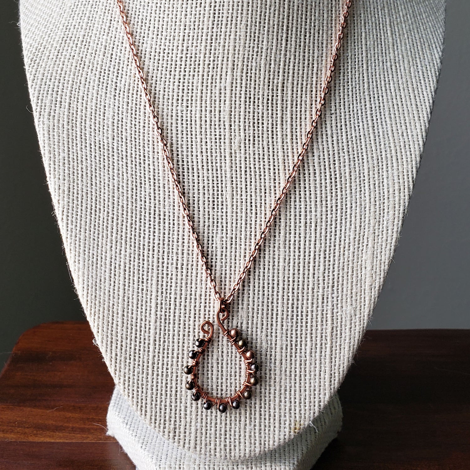 Wire wrapped hand hammered copper elongated horseshoe necklace