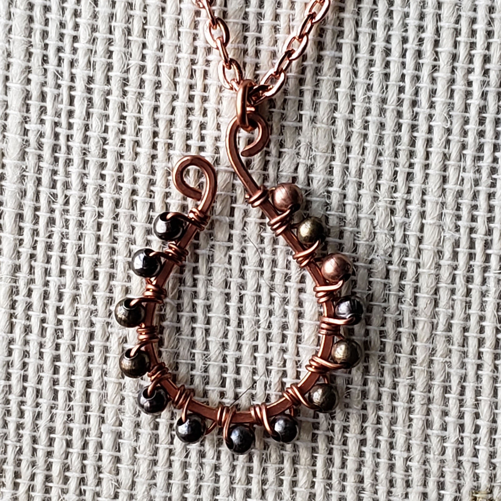 Wire wrapped hand hammered copper elongated horseshoe necklace